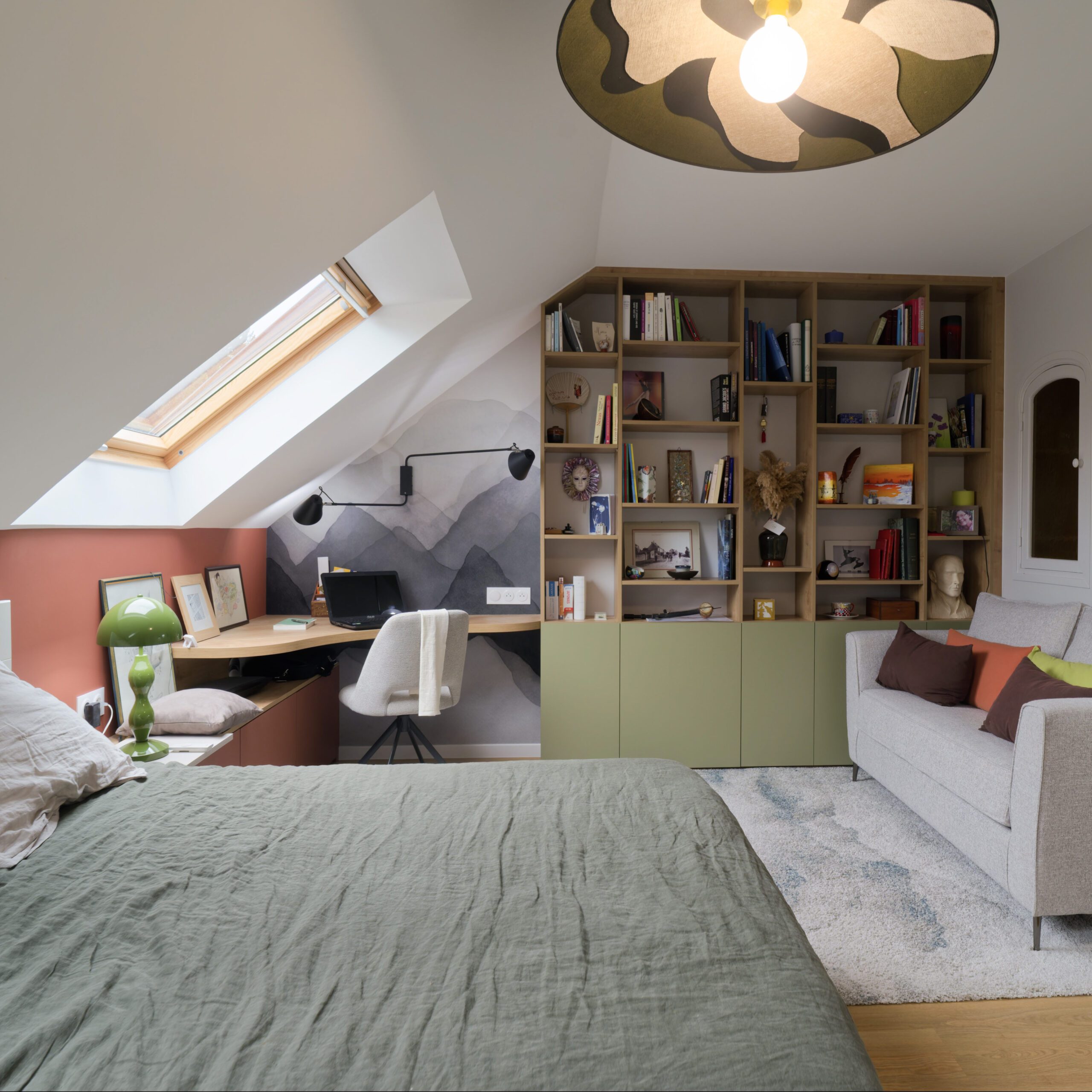Chambre sous combles aménagée sur mesure avec bibliothèque intégrée, bureau, rangements et espace détente dans des tons naturels et chaleureux.